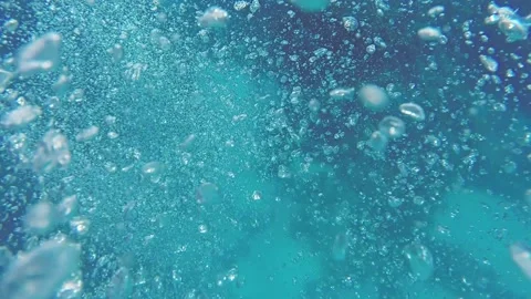 Many large bubbles in the azure sea water and scuba divers at the bottom of the  Stock Footage 233449474