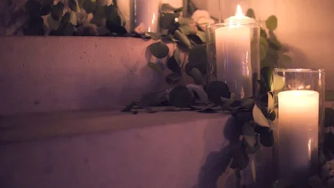 Many large candles burn inside glass glasses. Large, tall wedding candles 库存影片 124433029