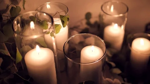 Many large candles burn inside glass glasses. Large, tall wedding candles Stock Footage