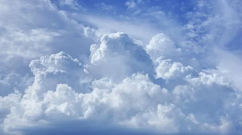 Many large white clouds in the sky formed a shape that resembled a mountain. Stock Photos