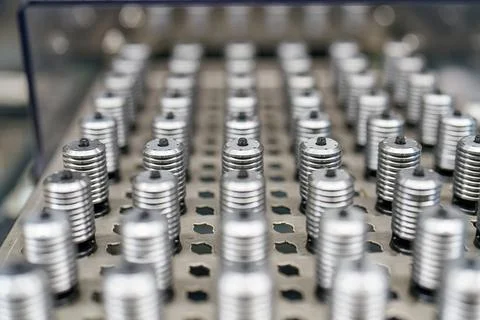 Many metal objects lined up on a surface in a factory during the day 库存照片