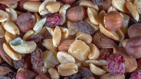 Many mixed nuts and dried fruits at rotating background - looping video Stock Footage 168937112