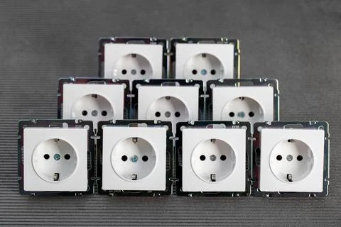 Many modern electrical sockets on a gray background, close-up. Rise in the price Foto stock