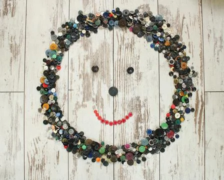 Many multi colored buttons form an abstract frame on a wooden table Stock Photos