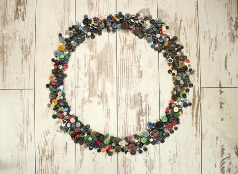 Many multi colored buttons form an abstract frame on a wooden table Stock Photos