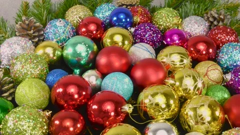 Many multi-colored Christmas balls among the Christmas tree branches in motion Stock Footage 159738626
