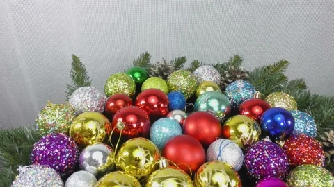 Many multi-colored Christmas balls rotate on a light background Stock Footage 159738658