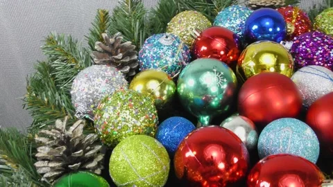 Many multi-colored Christmas balls rotate on a light background Video stock 159738664