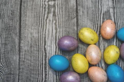 Many multi colored easter eggs on the wooden background. Stock Photos