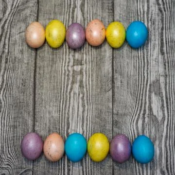 Many multi colored easter eggs on the wooden background. Stock Photos