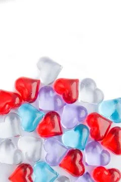 Many multi-colored hearts lie on a white background. Stock Photos