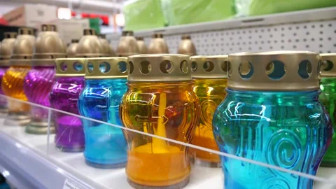 Many multi-colored lamps with candles for cemeteries on a store shelf. Stock Footage 287945565
