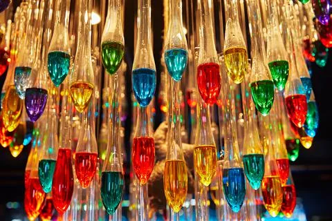 Many multi-colored light bulbs in the form of drops hang on the ceiling Stock Photos