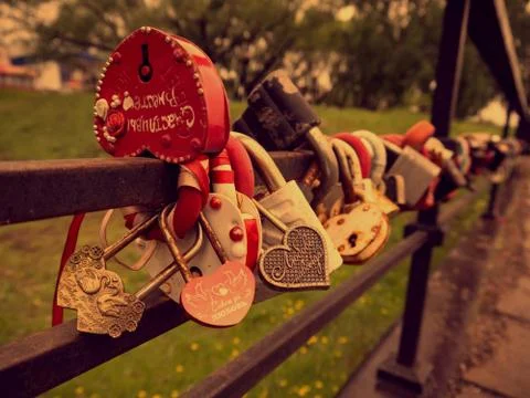 Many multi-colored padlocks on the bridge. Symbols of fidelity and love are p Stock Photos