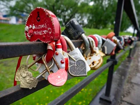 Many multi-colored padlocks on the bridge. Symbols of fidelity and love are p Stock Photos