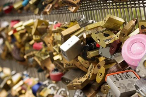 Many multi-colored padlocks with inscriptions hanging on the bridge supports Stock Photos