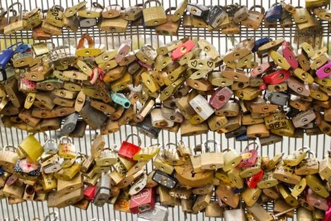 Many multi-colored padlocks with inscriptions hanging on the bridge supports 스톡 사진