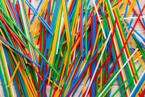 Many multi-colored plastic tubes for cocktail on Colored background, top view Stock Photos