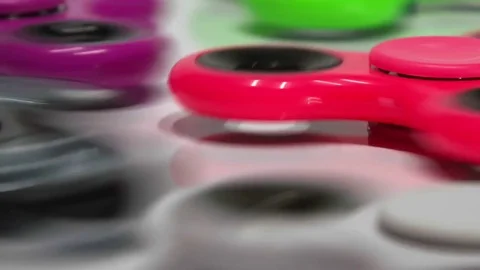 Many multi-colored spinners spinning on a white background Stock Footage 77735493
