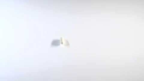 Many multicolored tablets fall on the table.A huge number of pills falling Stock Footage 127620517