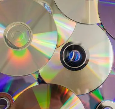 Many old CDs represent technology from the 90s. Stacks of CDs, old songs an.. Stock Photos