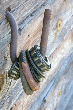 Many old rustic weathered large roller with ball bearing on iron hook, dried  Foto stock