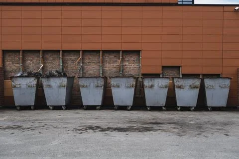 Many old rusty trash cans standing in a row Stock Photos