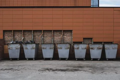 Many old rusty trash cans standing in a row Stock Photos