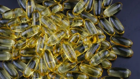 Many omega 3 capsules closeup is coming to tablets and blurred the background. Stock Footage 127367116