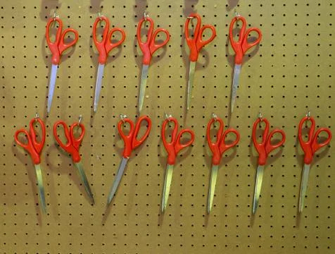 Many orange plastic scissors hanging on the wood background Stock Photos