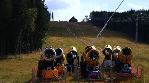 Many orange snow guns under mountain lift in Carpathian Mountains Stock Footage 59774624