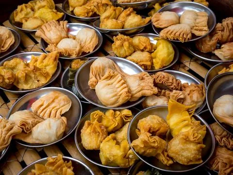 Many oriental crispy deep fried wontons in small stainless steel mini bowl .. Stock Photos