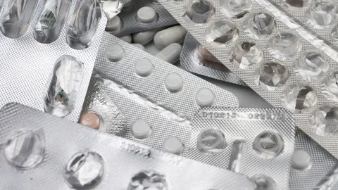 Many packed pills rotating on white background Stock Footage 81461216