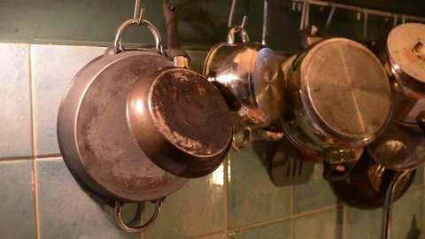 Many Pans in the Kitchen, a Man takes a Pan for Cooking Stock Footage 84384698