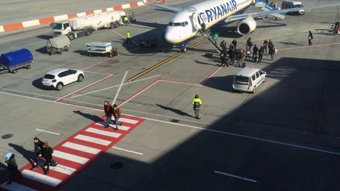Many passangers are getting off from a Ryanair airplane and walk to terminal. Stock Footage 103485318