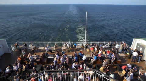 Many passengers drinking in the restaurant at the stern of a large sea vessel. Video stock 64022571