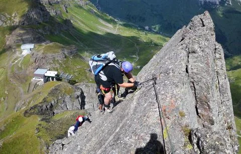 Many people climbing via ferrata delle Trincee near Arabba in the Dolomites ( Stock Photos
