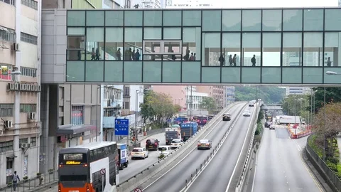 Many people go inside skybridge above Kwai Chung Road, vehicles on throughway Stock Footage 75656850