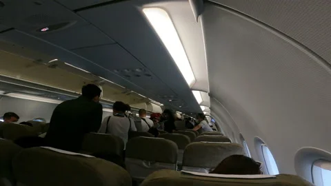 Many people on passageway inside the plane and looking for a seat in the planes Stock Footage 147420329
