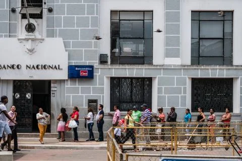 Many people standing in queue waiting in front of bank (Banco Nacional) bulin Stock Photos