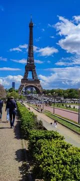 Many people walk near the Eiffel Tower in Paris Stock Photos