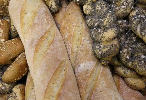 Many pieces of fresh bread in the bakery with fragrant loaves and baguettes Stock Photos