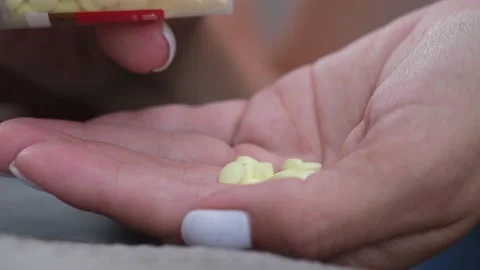 Many pills falling from meds bottle in woman's hand. Video stock 219861041