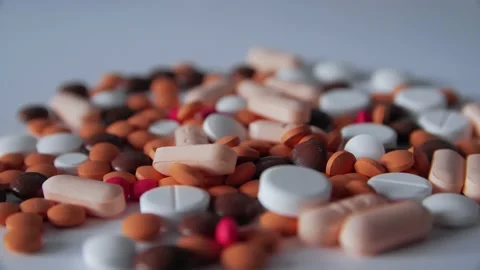 Many pills spill on white background. Different pills falling. Stock Footage 237768987
