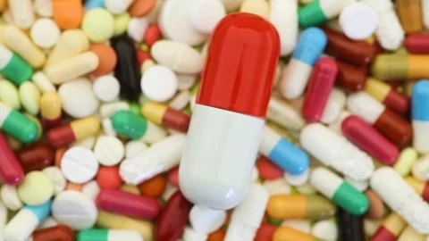 Many pills spinning with large one in the center Stock Footage 95913096