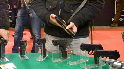 Many pistols on the table and hands Stock Footage 81590631