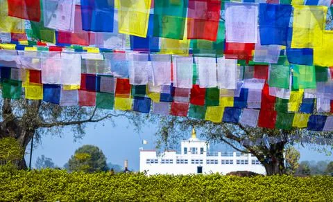 Many prayer flags in the wind against the Holy Maya Devi Temple in Lumbini, N Stock Photos