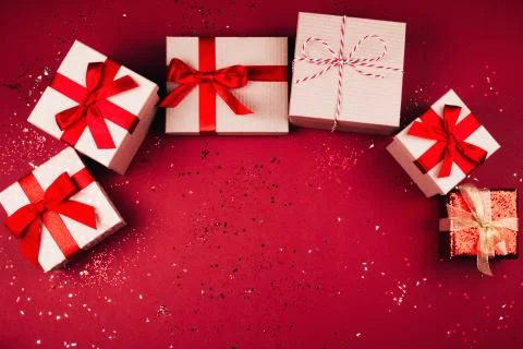 Many present boxes with red bow on red background Stock Photos