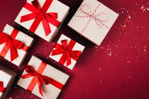 Many present boxes with red bow on red background Stock Photos