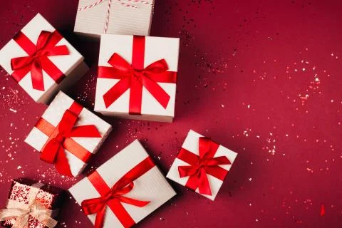 Many present boxes with red bow on red background Stock Photos